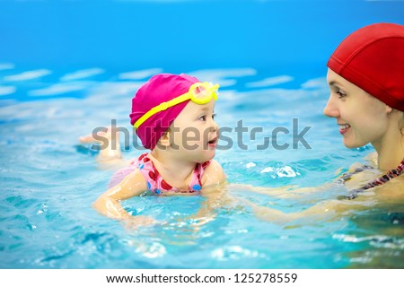 One year  baby girl at his first swimming lesson with mother
