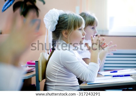Schoolgirls fingers clasped in prayer in the classroom