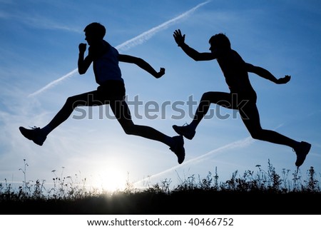 Two men make jog in the field on a sky background by at sunset