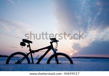The lonely bicycle has got stuck in snow on the big lake