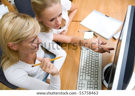 Portrait of beautiful young women working together in the office of the computers