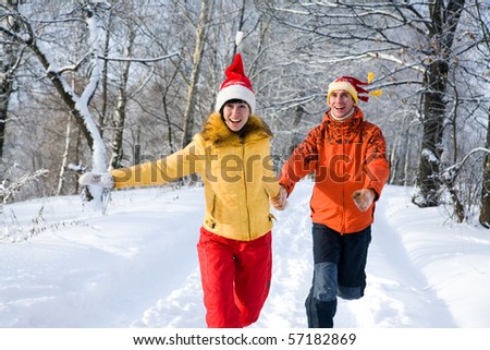 The young couple runs on winter wood