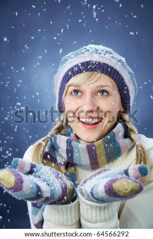 WINTER PORTRAIT OF BEAUTIFUL SMILING WOMAN WITH SNOWFLAKES
