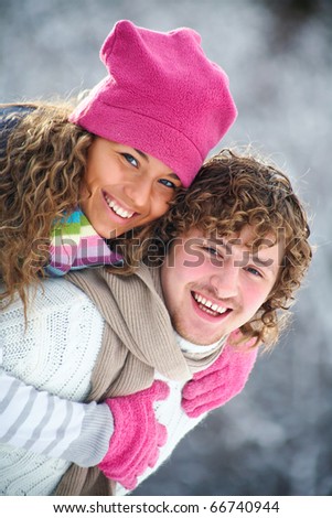 young playful couple has a fun winter time in a snow park