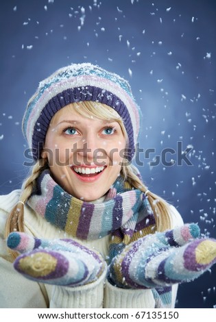 WINTER PORTRAIT OF BEAUTIFUL SMILING WOMAN WITH SNOWFLAKES