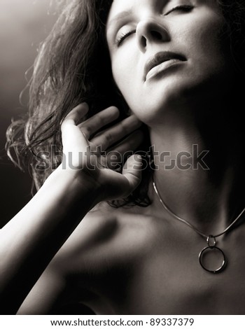 sensual beautiful woman touches her fingers to the neck. monochromatic