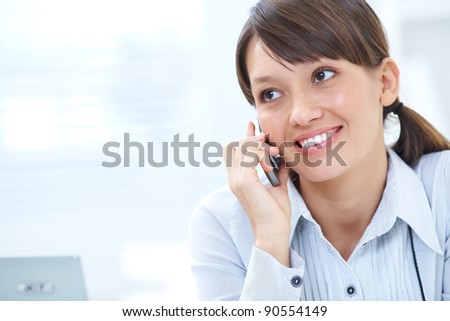 young brunette with glasses smiling talking on cell phone in office