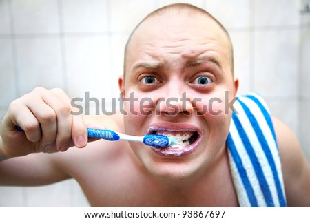 funny man furiously brushing his teeth in the bathroom
