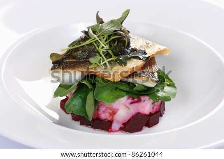 Pan-fried sea bass on a bed of crushed potato and beetroot with watercress salad