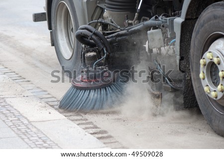 A sweeping machine cleans the street