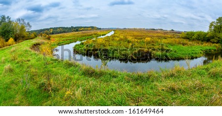 Autumn landscape, colorful leaves on trees, morning at river after rainy night. Panorama