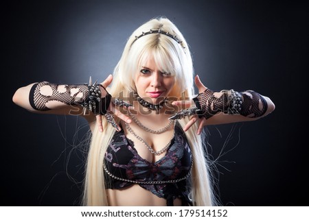 attractive woman with blade metal claw, studio shot on a black background
