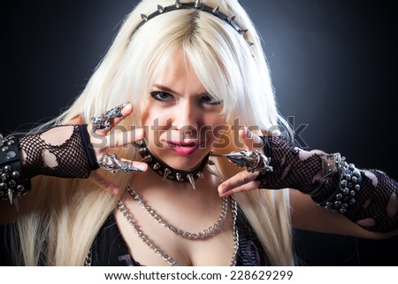 attractive woman with blade metal claw, studio shot on a black background