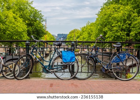 AMSTERDAM, NETHERLANDS - AUGUST 19: Bicycles on a bridge over the canals of Amsterdam. Amsterdam is the capital and most populous city of the Netherlands on August 19, 2014