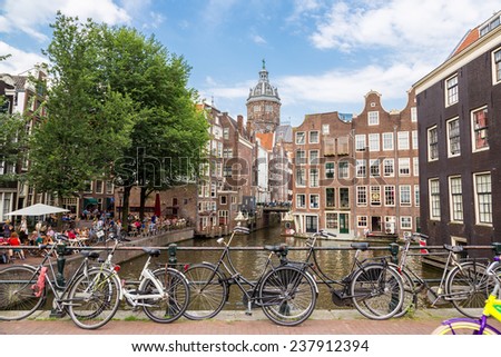 AMSTERDAM, NETHERLANDS - AUGUST 19: Bicycles on a bridge over the canals of Amsterdam. Amsterdam is the capital and most populous city of the Netherlands on August 19, 2014