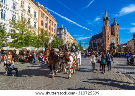 KRAKOW, POLAND - JUNE 16: Horse carriages at main square in Krakow in a summer day, Poland on June 16, 2014