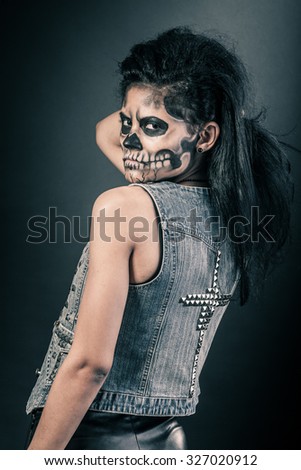 Young woman in day of the dead mask skull face art. Halloween face art