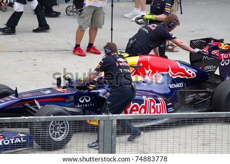 SEPANG, MALAYSIA - APRIL 8: Australian Mark Webber of Red Bull Racing being pushed back into the pit garage after Friday practice at Petronas Formula 1 Grand Prix on April 8, 2011 in Sepang, Malaysia
