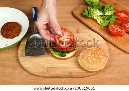 Making Hamburger. Series. 10/15. Put Tomato on Patty.