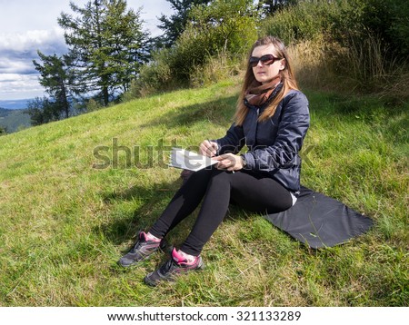 Woman artist working en plein air in mountains.