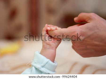 Baby clings to mother\'s finger