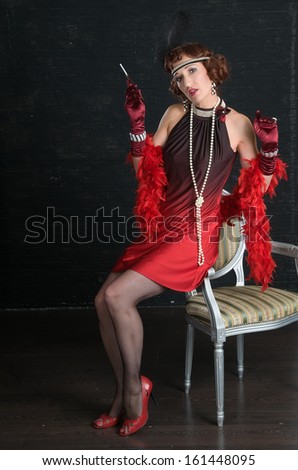 Retro Woman Portrait. Beautiful Woman with Cigarette sits on the back of a chair