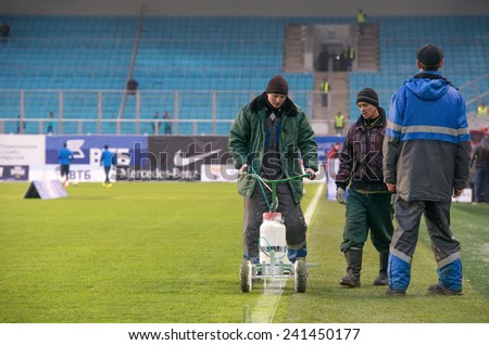 MOSCOW - DECEMBER 7 Work on the stadium draws a line on the field before the game Dynamo (Moscow) vs Amkar (Perm) on Russian Premier League on December 7, 2014, in Moscow, Russia