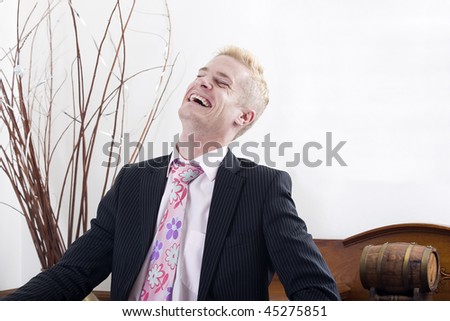 Portrait of a young business man laughing in a pinstripe suite.