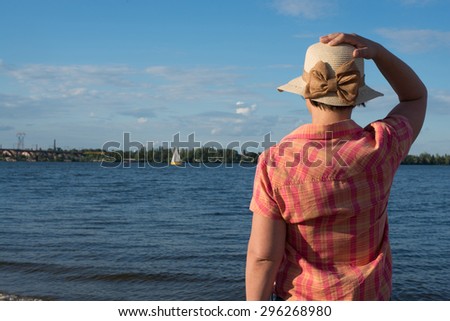 Woman in a straw hat looks afar