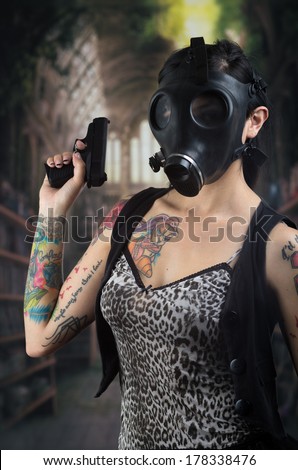 Woman with gas mask and gun in a grunge background