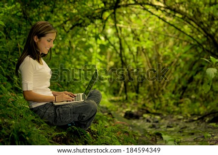 woman in the forest using a laptop