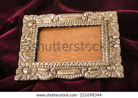 old metallic silver photo frame over red velvet textile
