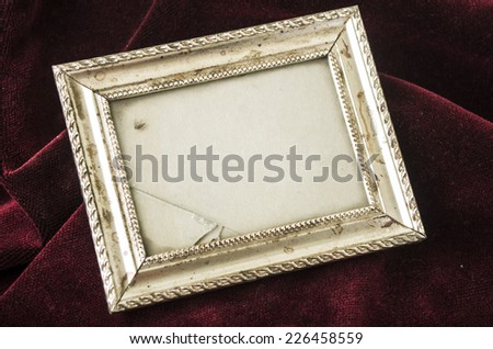 old metallic silver broken photo frame over red velvet textile