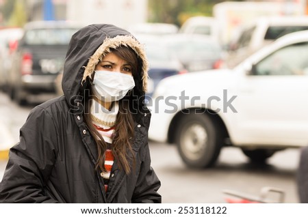 portrait of young girl walking wearing jacket and a mask in the city street concept of  pollution
