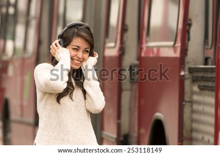 portrait of woman walking on the city street wearing headphones concept of noise pollution