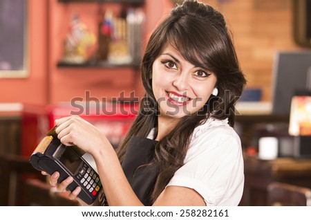 beautiful young friendly waitress swiping credit card
