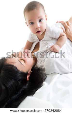 cute baby boy lying on mom\'s chest looking at camera