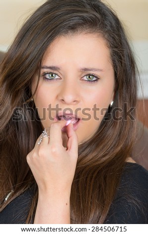 closeup pretty brunette holding a pill in front of mouth moment before swallowing