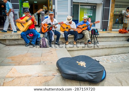 ARMENIA, COLOMBIA - FEBRUARY 23, 2015: Unidentify indigenous men playing guitar in the commercial street plaza and collectin money of Armenia