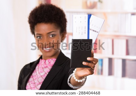 Black office woman holding passport document towards camera concept transport airplane airline bus train traveling airport counter depart flight