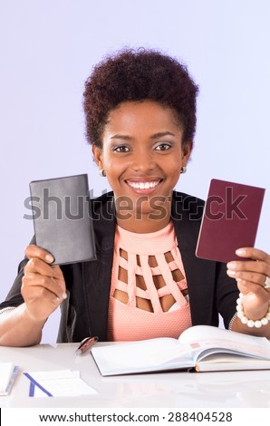 Friendly black office woman sitting by desk holding up passport documents concept transport airplane airline bus train traveling airport counter depart flight