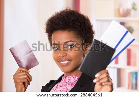 Black office woman holding up tickets and passport document smiling concept transport airplane airline bus train traveling airport counter depart flight