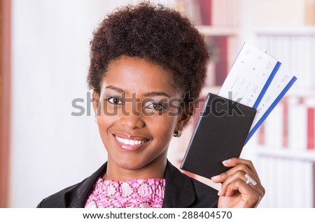 Black office woman showing tickets to camera concept transport airplane airline bus train traveling airport counter depart flight