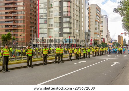 QUITO, ECUADOR - JULY 7, 2015: A long line police officers guarding the street as crowds await arrival of Pope Francis motorcade in relations to South America tour first stop Quito, Ecuador.
