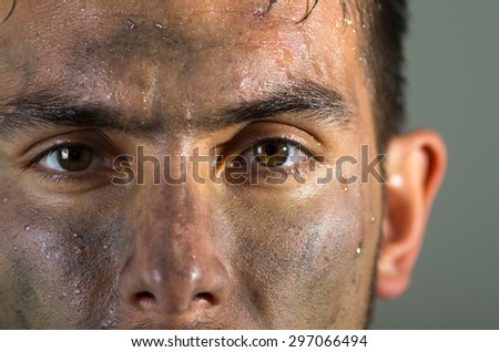 Closeup hispanic man dirty face eyes and nose caption looking to camera.