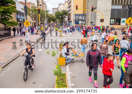 BOGOTA, COLOMBIA - FEBRUARY 9, 2015: Unidentified hispanic pedestrians and cyclists moving through city street Candelaria area Bogota