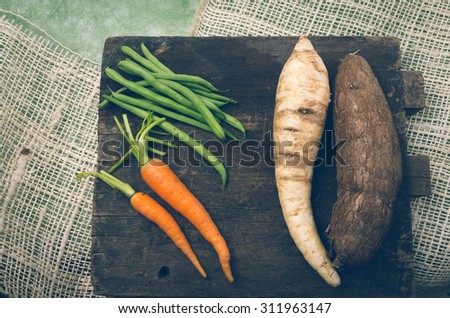 delicious carrots, beans, white carrot and sweet potato on wood.