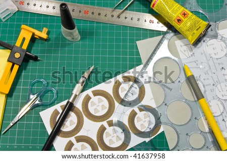 Different cutting and gluing hobby tools (rulers, knifes, paper,cardboard, cutting mat, pen, scissors, tweezers) still life composition.