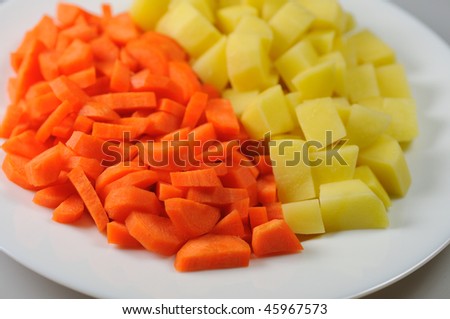 Slices of raw carrots and potatoes on a white plate