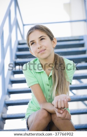 Portrait of Smiling Tween Girl Sitting On Stairway